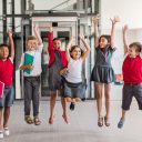 a-group-of-cheerful-small-school-kids-in-corridor-jumping.jpg