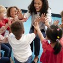 infant-school-children-in-a-circle-in-the-classroom-giving-high-fives-to-their-teacher.jpg